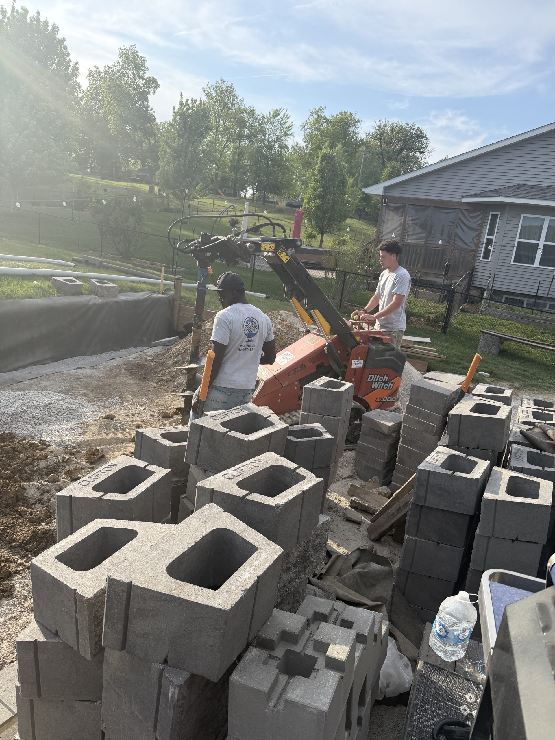 Retaining wall under construction in Iowa, blocks being set on a compacted base