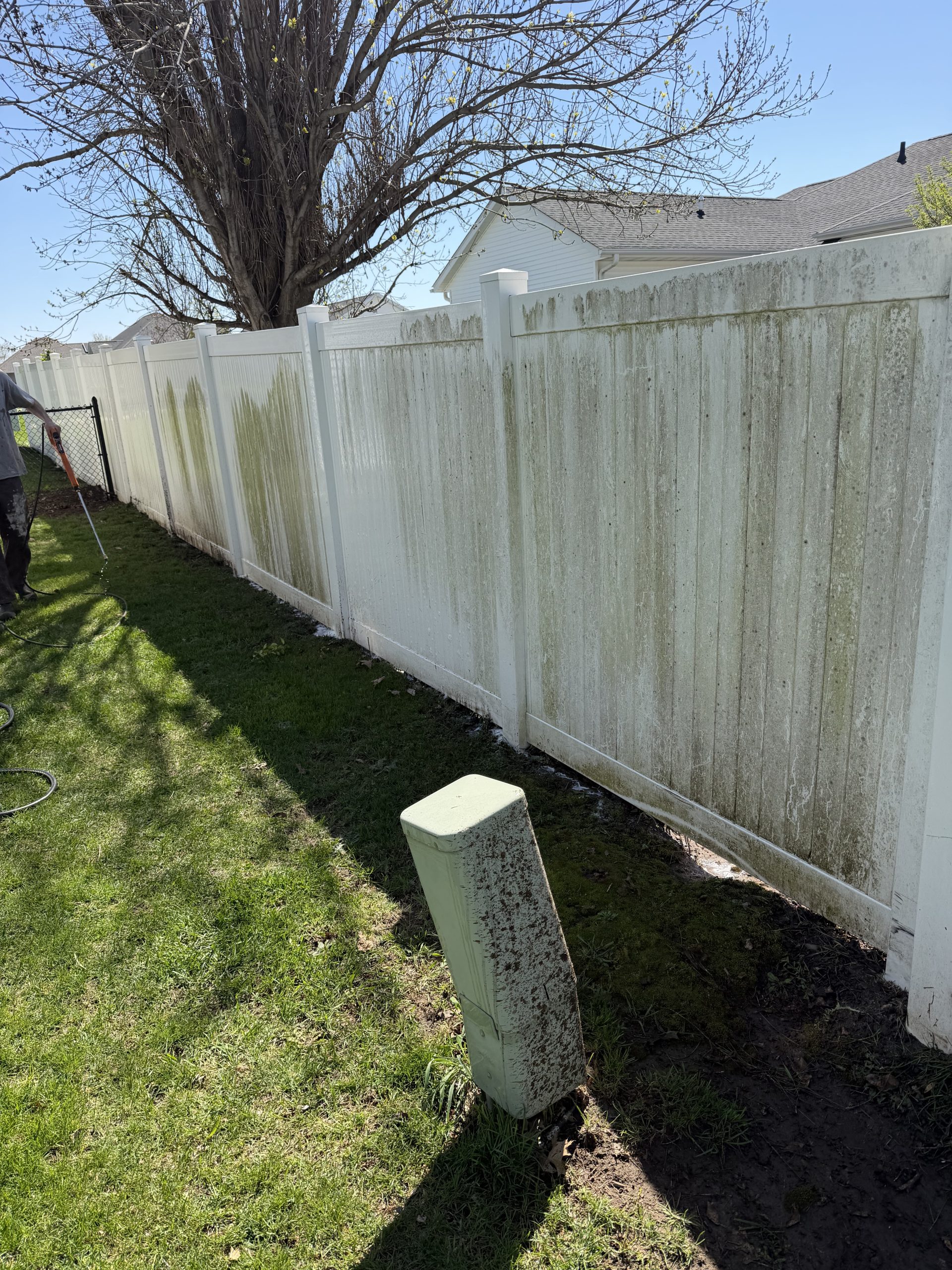 Dirty wooden fence before power washing, covered in grime and algae