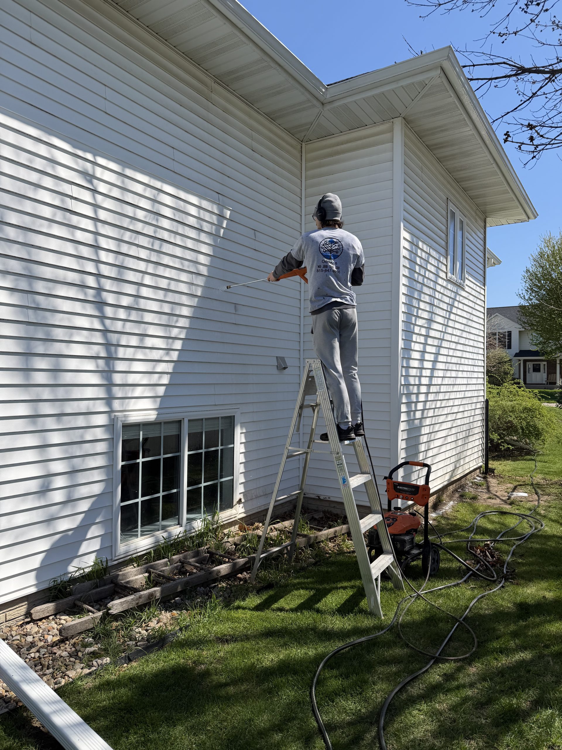 OddJobs team power washing a house exterior in Marion, Iowa